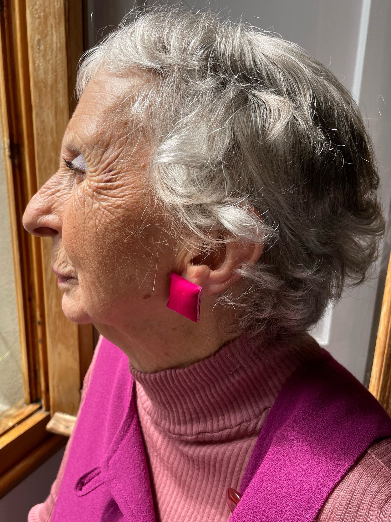 Big Candy rosa indossato da una signora con i capelli bianchi corti e un cappotto fucsia