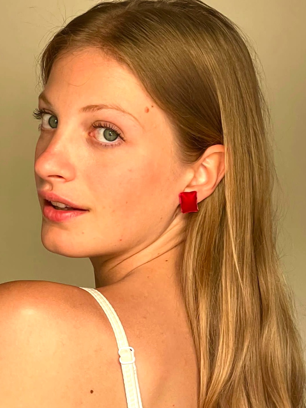 Candy rosso indossato sul lobo, capelli biondi lunghi
